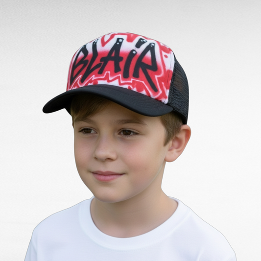 Child wearing a cap with 'BLAIR' airbrushed on a red design against a plain background