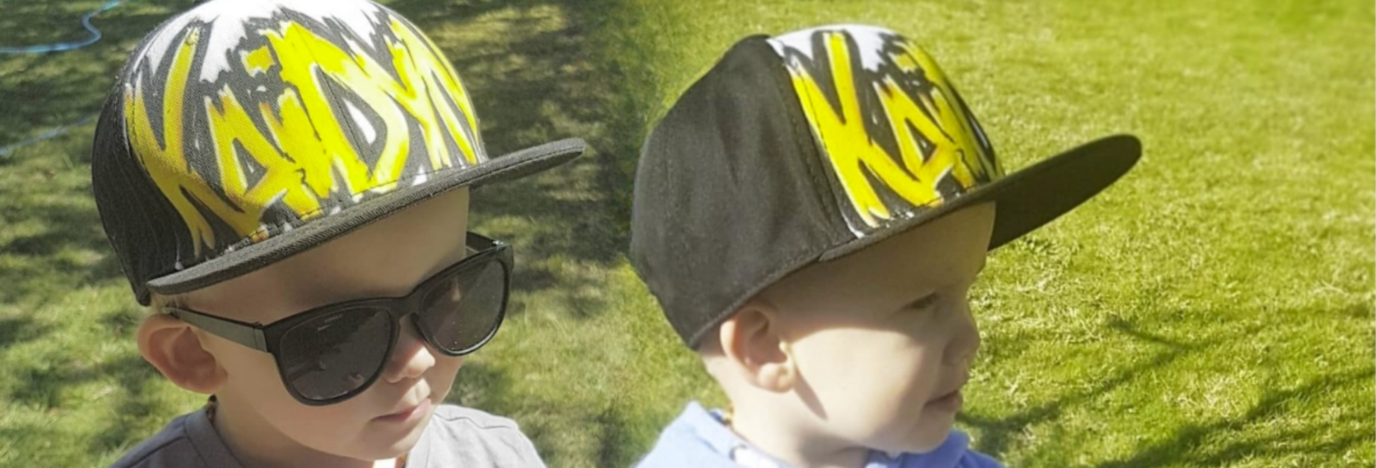 Two children wearing snapback caps with personalised airbrush name designs on a grassy background.