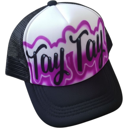 Black Trucker hat with 'Tay Tay' script text airbrushed with a purple design on a white background