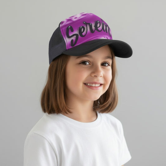 Child wearing a black trucker cap with purple purple airbrush design with 'Serena' in script on a gray background