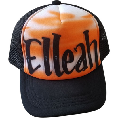 Black trucker cap with 'Elleah' airbrushed on it with a orange design against a white background