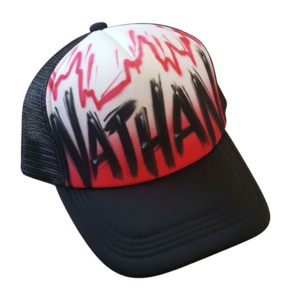 Black trucker cap with 'Nathan' airbrushed with a red design on a white background