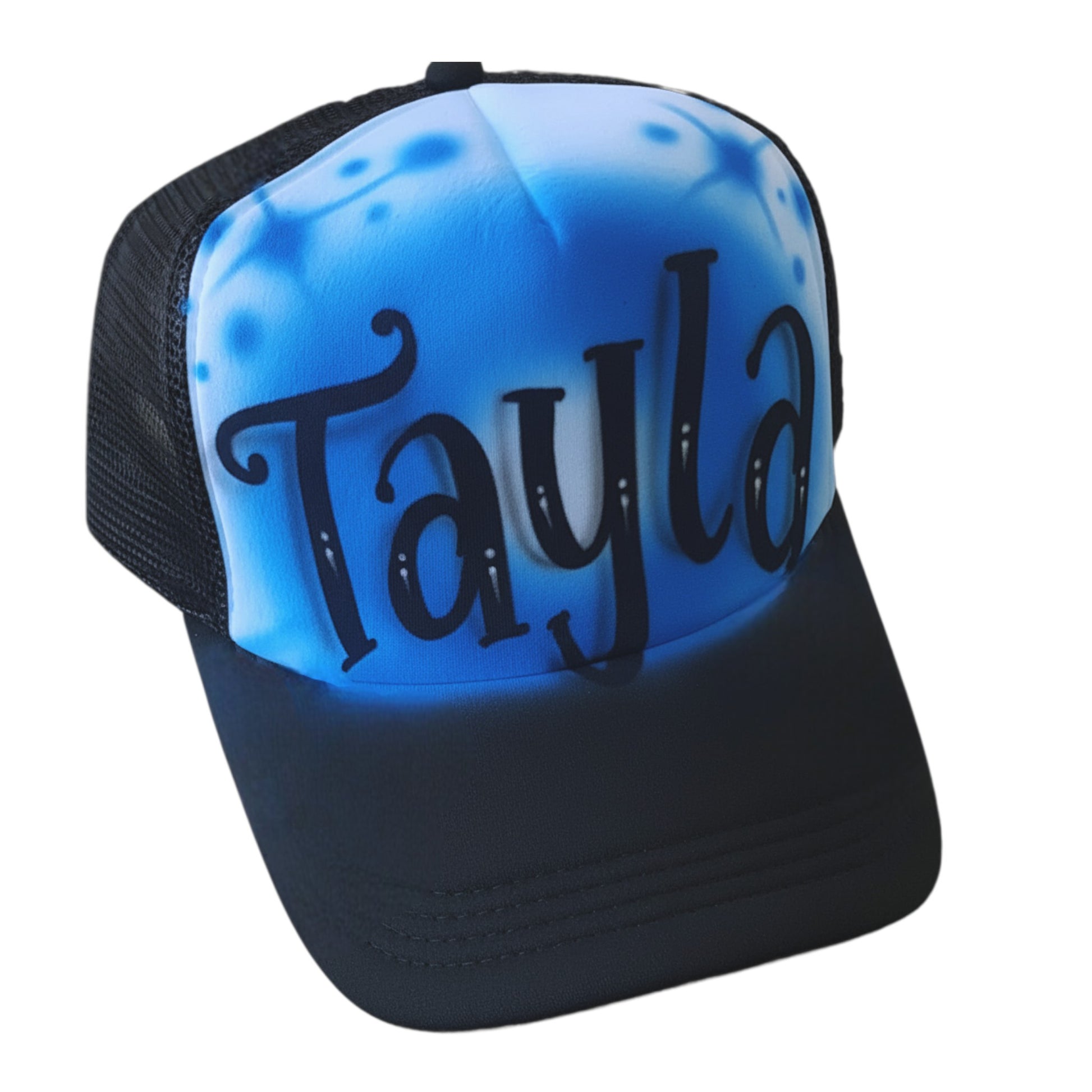 Black trucker cap with 'Tayla' airbrushed on it with a blue design against a white background